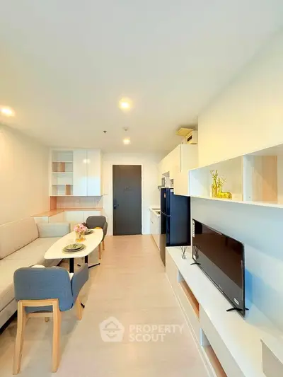 Modern living room with stylish furniture and open kitchen layout in a bright apartment.