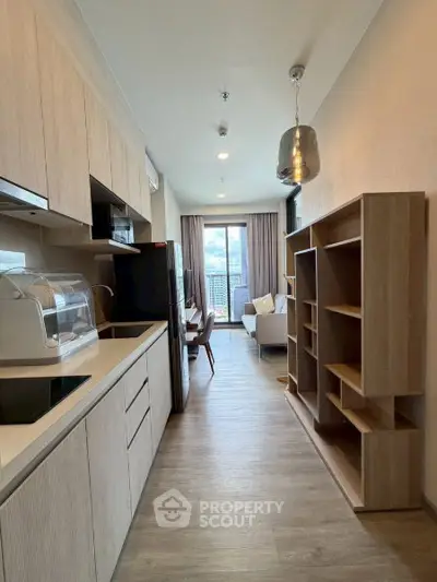 Modern open-layout kitchen leading to a cozy living room with city view.
