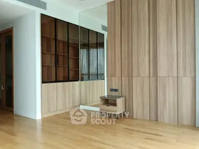 Spacious modern living room with wooden flooring and built-in storage
