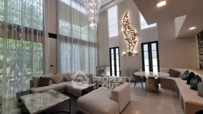 Luxurious living room with high ceilings, elegant chandelier, and modern decor