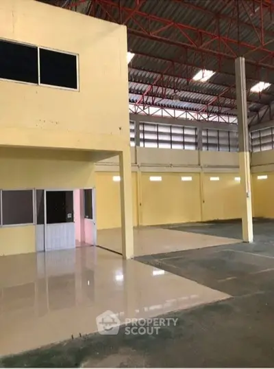 Spacious industrial warehouse with high ceilings and ample natural light.