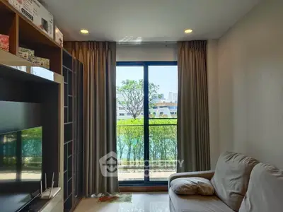 Cozy living room with large window and garden view, featuring modern decor and comfortable seating.