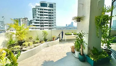 Spacious balcony with city view and lush greenery in modern apartment