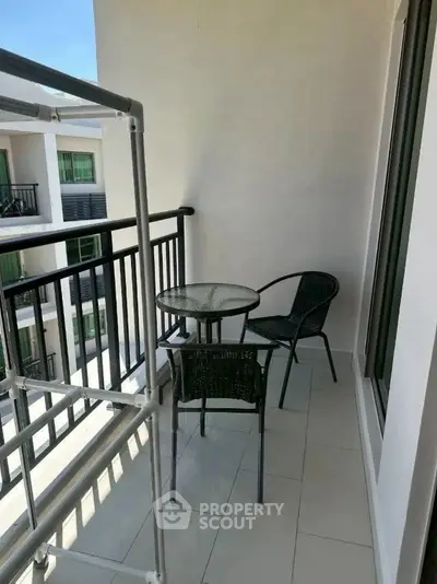 Charming balcony with cozy seating and modern railing, perfect for relaxation.