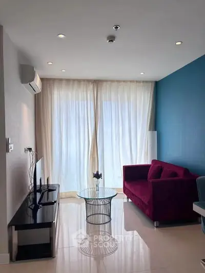 Modern living room with stylish red sofa and floor-to-ceiling windows.