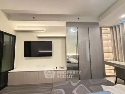 Modern bedroom with sleek design, built-in TV, and stylish storage solutions.