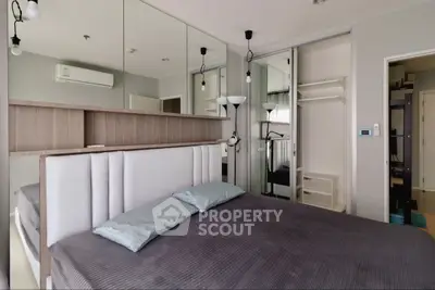 Modern bedroom with mirrored closet and stylish decor in a contemporary apartment.