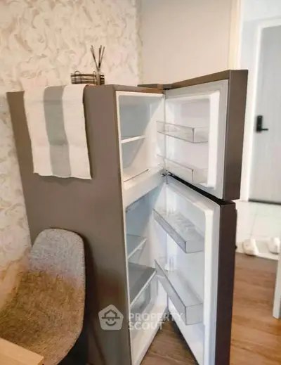 Modern kitchen with open fridge showcasing sleek design and ample storage space.