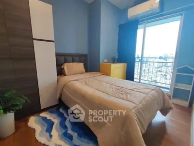 Cozy bedroom with city view, featuring modern decor and natural light.