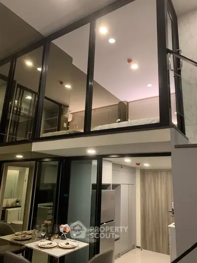 Modern duplex apartment with sleek glass walls and stylish dining area, showcasing contemporary urban living.