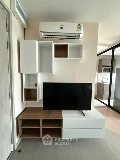 Modern living room with sleek TV unit and air conditioning, showcasing contemporary interior design.
