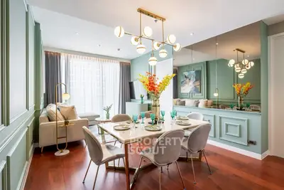 Elegant dining area with modern chandelier and stylish decor in a luxurious apartment.