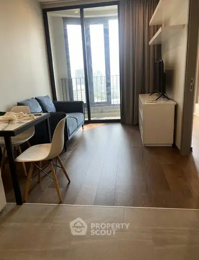 Modern living room with balcony view, sleek furniture, and natural light in a stylish apartment.