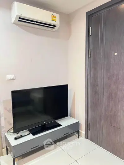Modern living room corner with TV and air conditioner in a stylish apartment.
