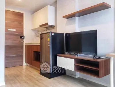 Modern compact living room with sleek TV setup and stylish kitchen area