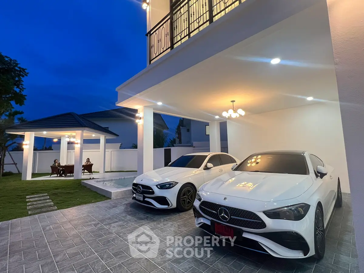 Luxurious modern home with spacious driveway and elegant outdoor lighting.
