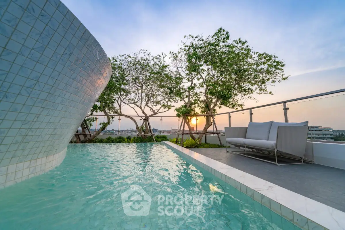 Luxurious rooftop pool with stunning sunset view and modern seating area.