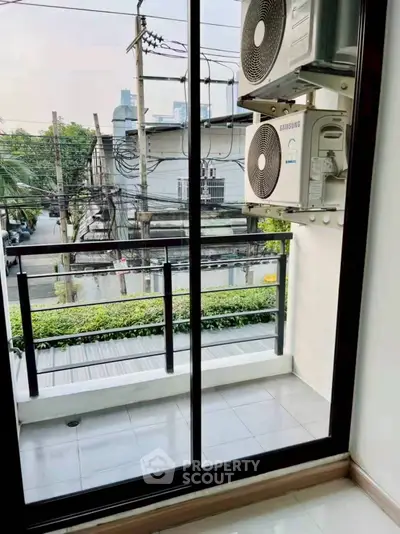 Charming small balcony with city view and air conditioning units, perfect for urban living.