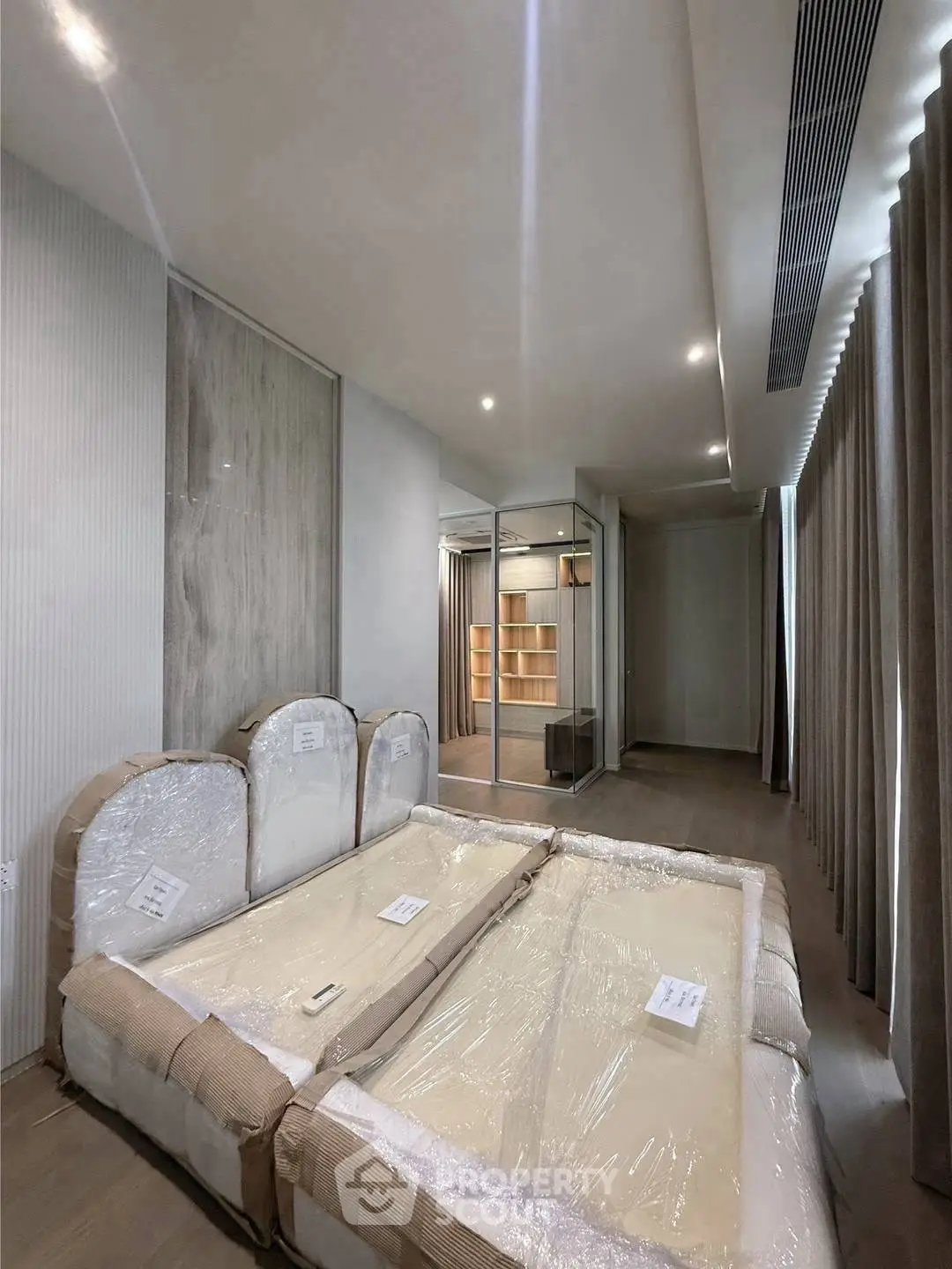 Spacious bedroom with modern design and ample natural light, featuring a large bed and stylish decor.