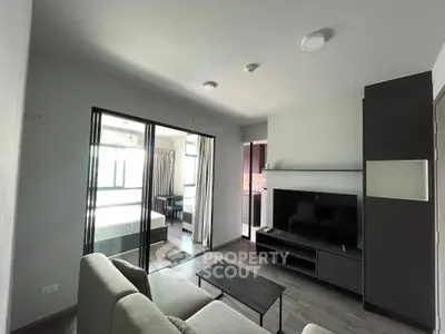 Modern living room with sleek furniture and open layout leading to a bedroom, perfect for urban living.