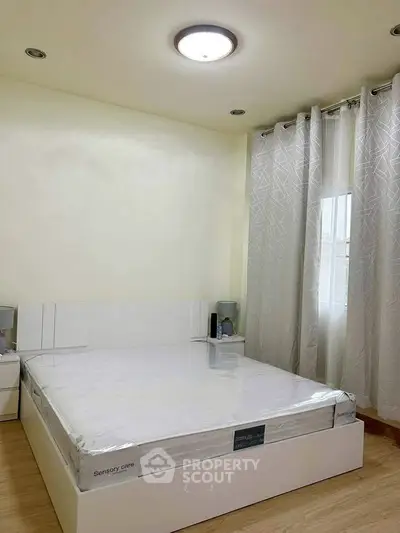 Modern bedroom with natural light and minimalist design, featuring a comfortable bed and stylish curtains.