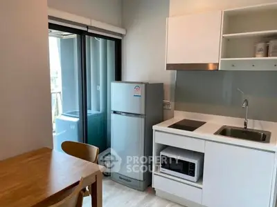 Modern kitchen with sleek appliances and balcony view, perfect for urban living.