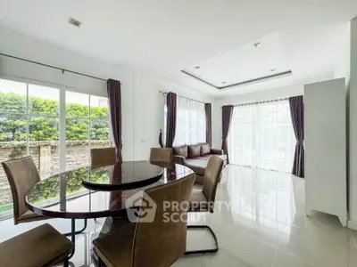 Spacious modern living room with elegant dining area and large windows for natural light.