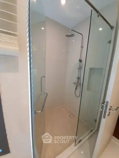 Modern bathroom with glass shower enclosure and sleek fixtures
