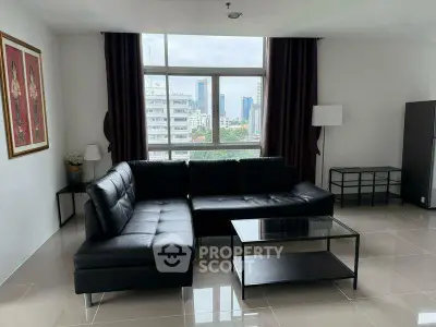 Spacious living room with modern black leather sofa and city view window.