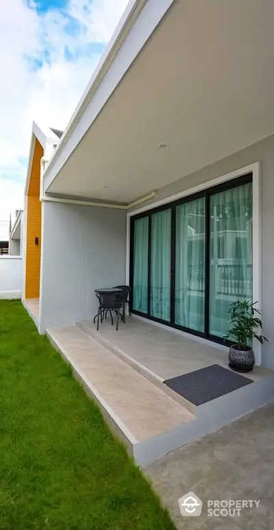 Modern house exterior with patio and sliding glass doors