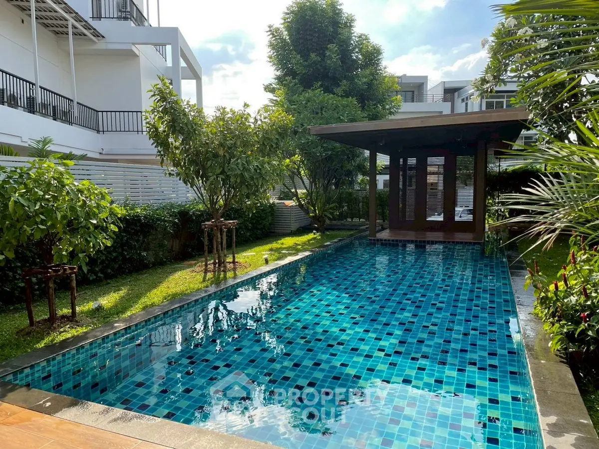 Luxurious private pool surrounded by lush greenery in a modern residential setting.