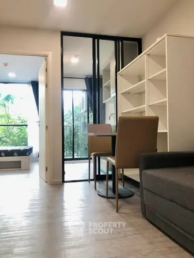 Modern apartment interior with open layout, featuring a cozy living area and a view of the balcony.