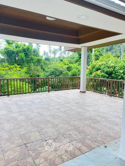 Spacious balcony with scenic green view, perfect for relaxation and outdoor gatherings.