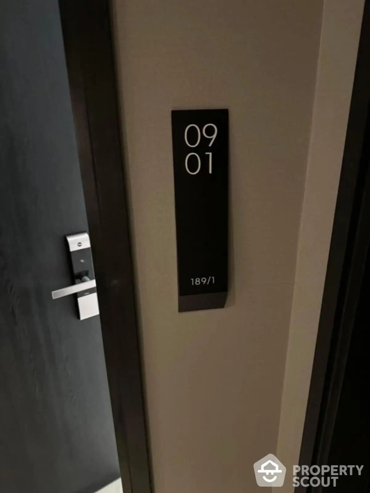 Modern apartment entrance with sleek door and room number signage.