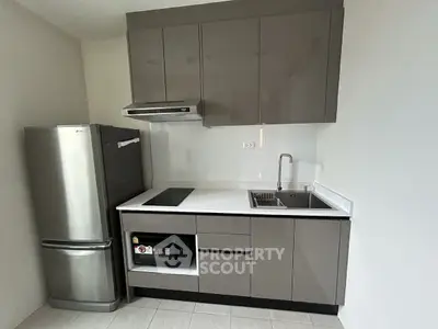 Modern compact kitchen with sleek cabinetry and stainless steel appliances.