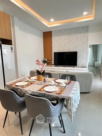 Modern dining area with elegant table setting and stylish TV unit