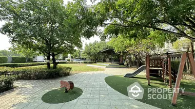 Charming garden with playground and lush greenery in a serene residential area.