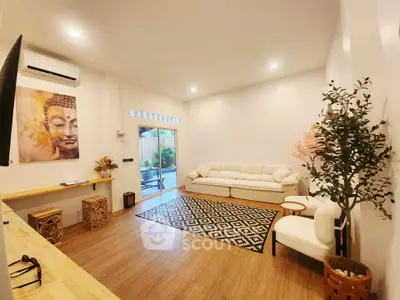 Spacious living room with modern decor and large window opening to garden view.