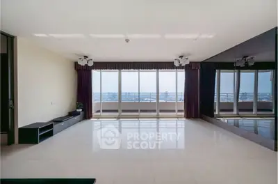 Spacious living room with floor-to-ceiling windows and stunning city view