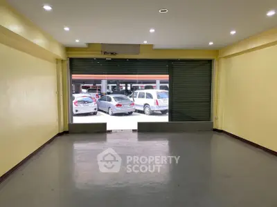 Spacious commercial space with large front windows and ample parking view.
