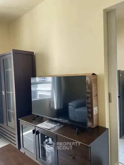 Modern living room with sleek TV stand and glass cabinet, perfect for stylish urban living.