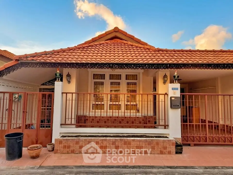 Charming single-story house with red tile roof and gated entrance, perfect for cozy living.