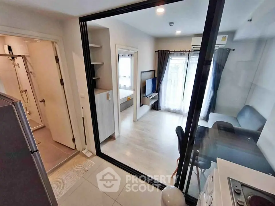 Modern apartment interior with open layout, featuring a cozy living room and adjacent kitchen area.