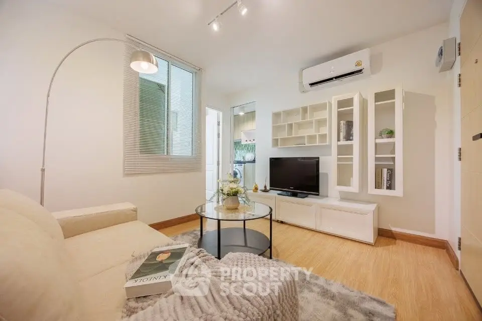 Modern living room with cozy sofa, stylish decor, and sleek TV unit in bright apartment.