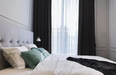 Luxurious bedroom with elegant decor and large window for natural light.