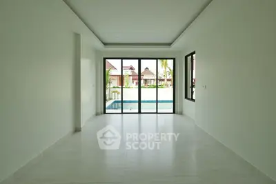 Spacious empty room with pool view through large windows