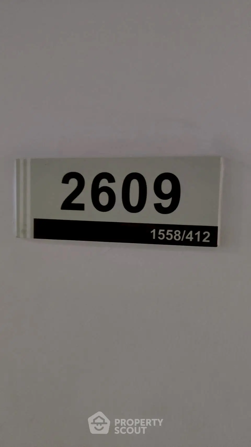 Apartment number 2609 sign on a white wall, indicating unit identification in a residential building.