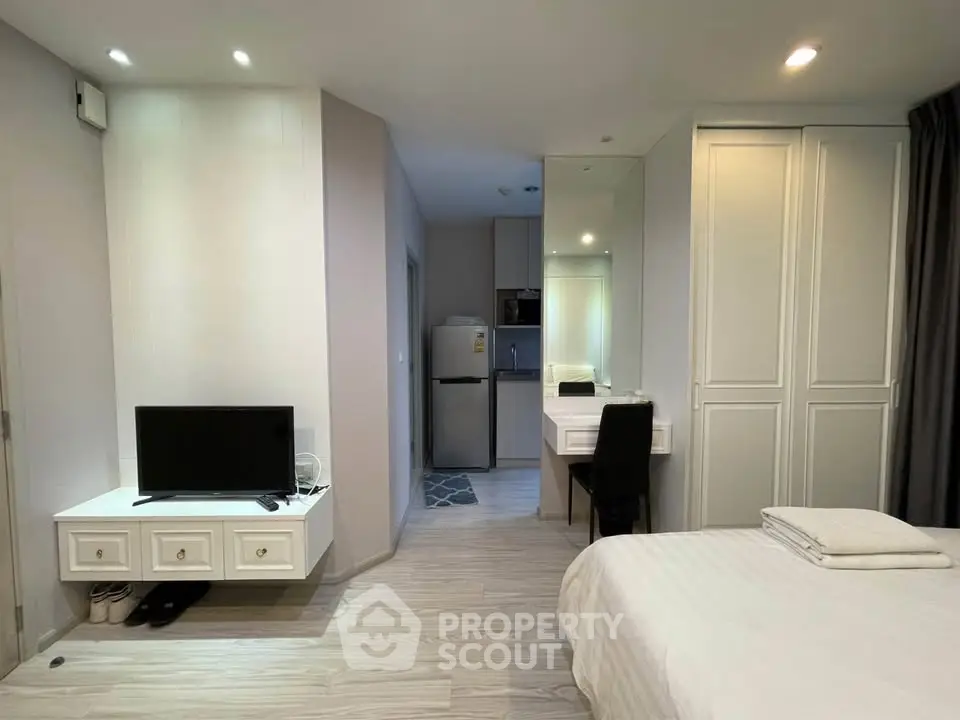 Modern studio apartment with sleek design, featuring a cozy bedroom, compact kitchen, and stylish decor.