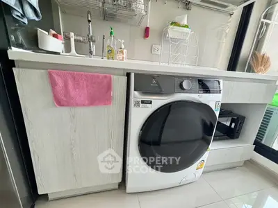 Modern laundry area with washing machine and sleek cabinetry