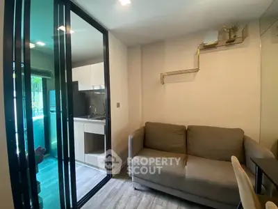 Modern living room with sliding glass doors and compact kitchen area